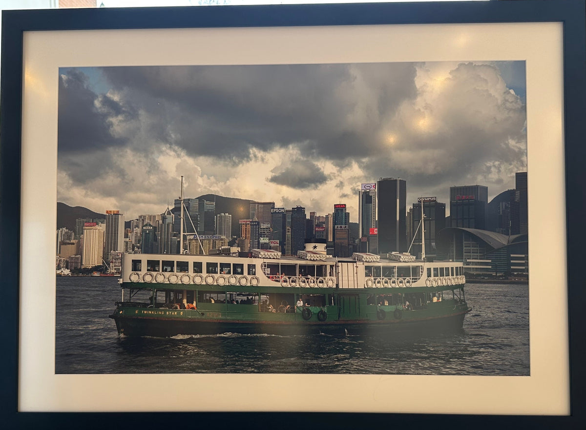 Framed photograph of a city skyline with a ferry on a table.
