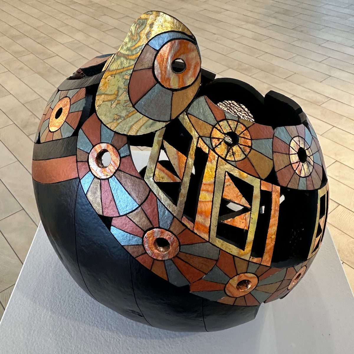 Decorative bowl with mosaic design on a light-colored floor.